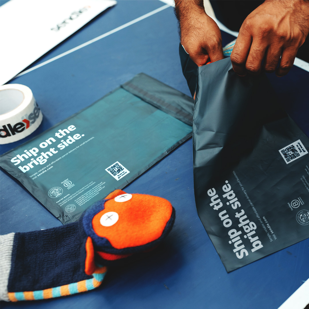 Man packing up his products using mailers satchels of Sendle